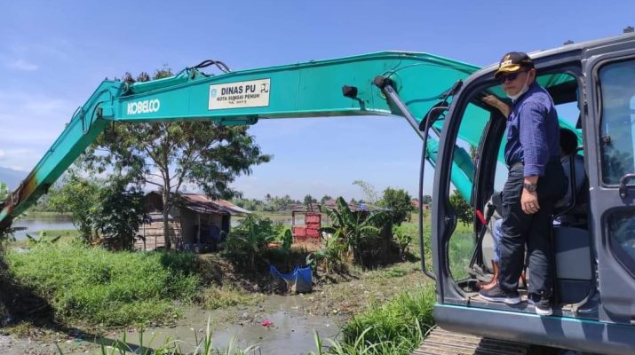 Langkah tepat dan tunjukkan komitmen tuntaskan titik banjir, Walikota Sungai Punuh ikut Gotong royong membantu warga. 