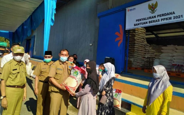 Pemerintah Kabupaten Kerinci Melakukan Pelepasan Penyaluran Bantuan Beras Pemberlakuan Pembatasan Kegiatan Masyarakat (PPKM) 2021, serta Penyerahan Bantuan kepada masyarakat terdampak PPKM di Gudang Perum Bulog Kerinci, Selasa (27/07/2021).